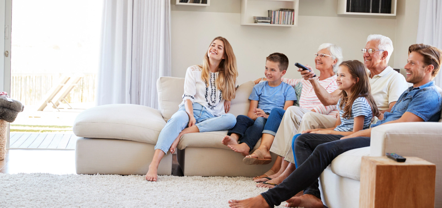 family laying on a couch watching tv